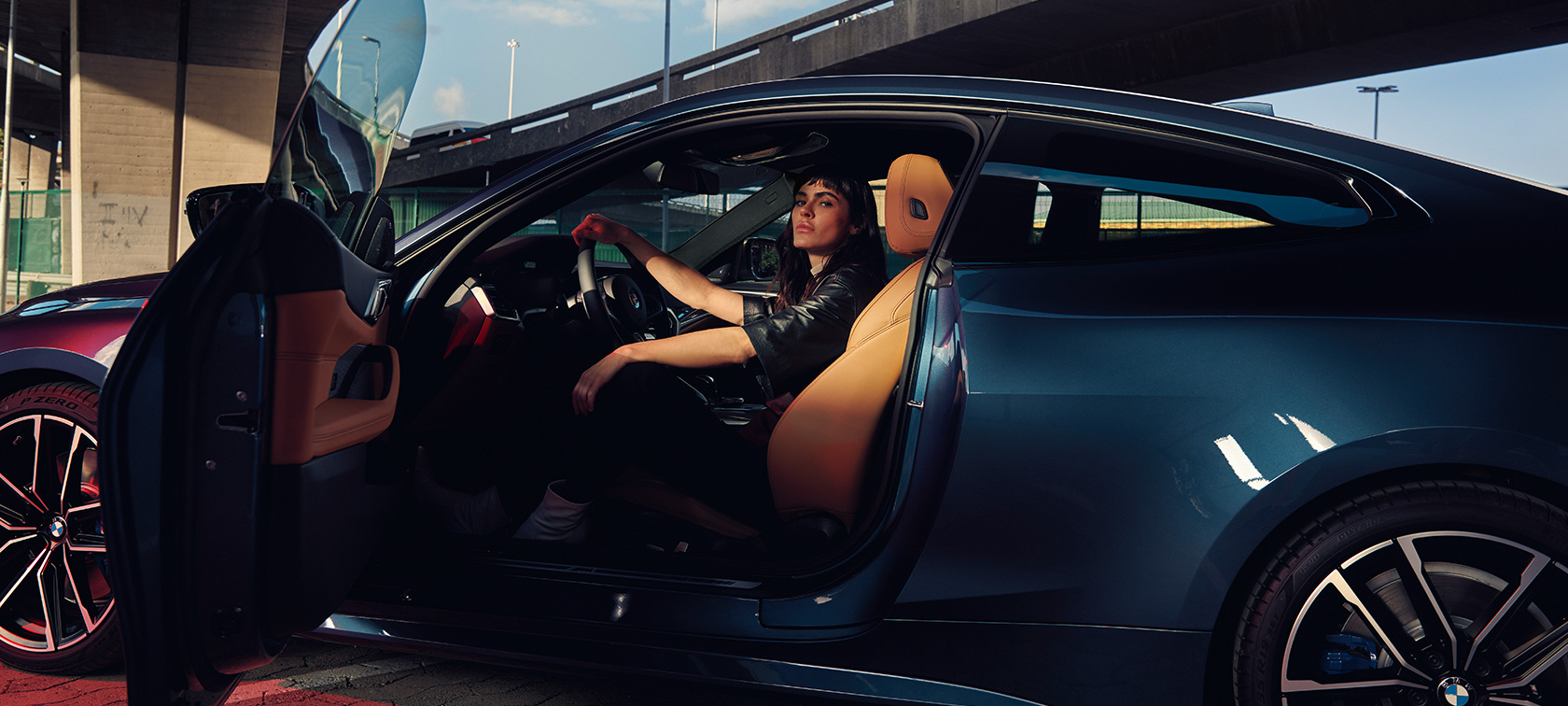 BMW M440i xDrive Coupé G22 2020 set fra siden med model BMW M440i xDrive Coupé G22 2020 Arctic Race Blue metallic set fra siden, model sidder i bilen med åben dør