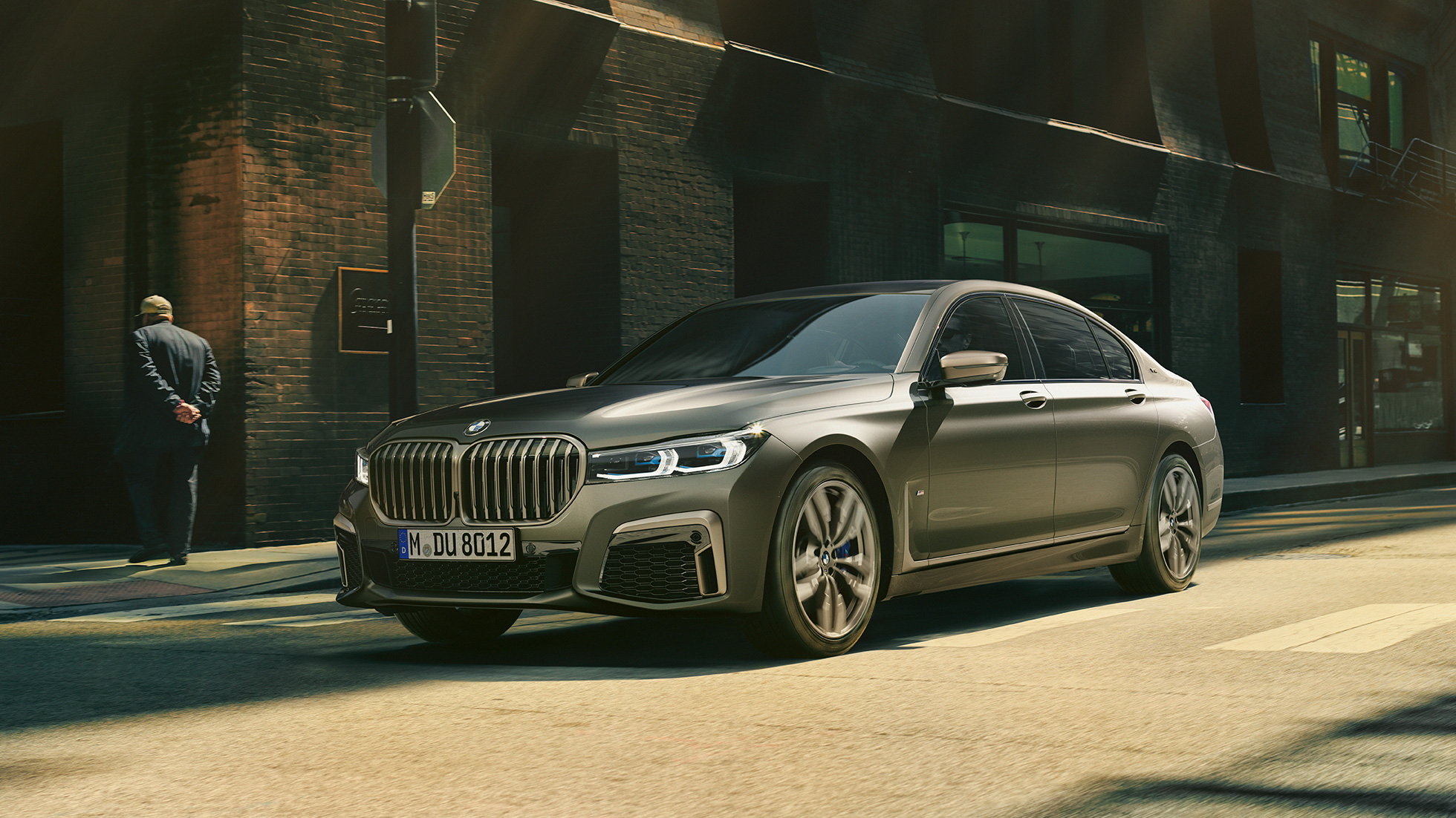 BMW M760Li xDrive Sedan i urbant miljø BMW M760Li xDrive Sedan set forfra lidt fra siden kører på gade i urbant miljø