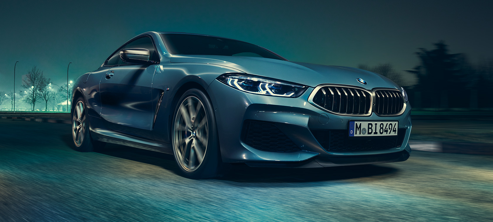 BMW M850i xDrive Coupé set forfra let drejet. BMW M850i xDrive Coupé i Barcelona Blue metallic i fart set forfra let drejet.