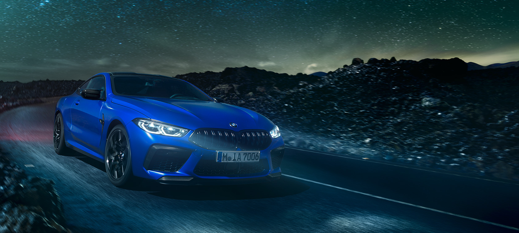 BMW M8 Competition Coupé set bagfra. BMW M8 Competition Coupé set bagfra, kørende om natten ved fuldmåne.