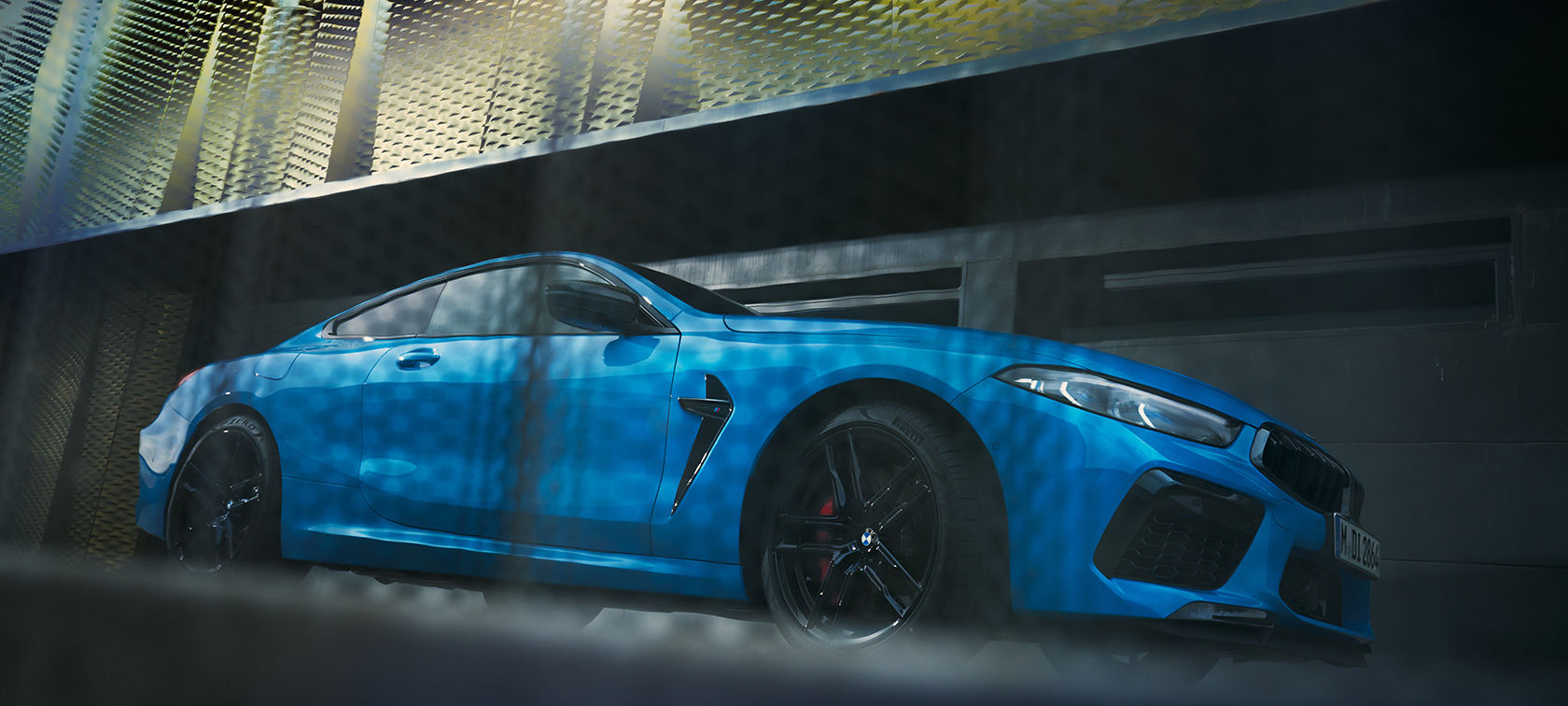 BMW M8 Competition Coupé F92 LCI Facelift 2022 set fra siden stående i frøperspektiv BMW M8 Competition Coupé F92 LCI Facelift 2022 BMW Individual Daytona Beach Blue uni set fra siden stående foran bygning i frøperspektiv