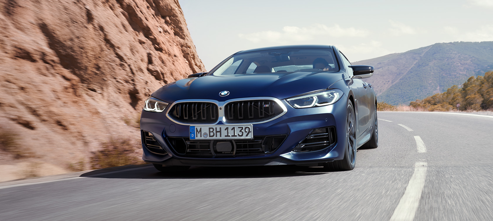BMW M850i xDrive Gran Coupé G16 LCI Facelift 2022 set forfra let drejet kørende BMW M850i xDrive Gran Coupé G16 LCI Facelift 2022 BMW Individual Frozen Tanzanite Blue metallic set forfra let drejet kørende i et sving