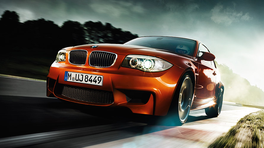 BMW Etter-serie M Coupé E82 set forfra let drejet kørende på vej BMW M-modeller BMW Etter-serie M Coupé E82 set forfra let drejet kørende på vej