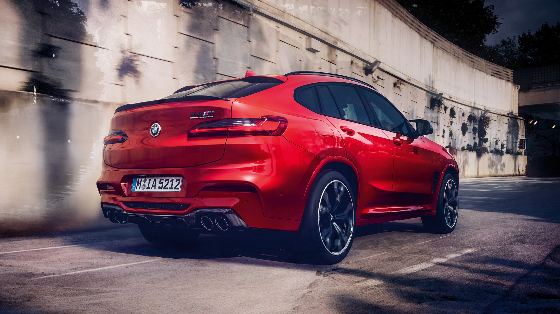 BMW X4 M Competition set bagfra let drejet. BMW X4 M Competition i Toronto rød-metallic, eksteriør, set bagfra let drejet.