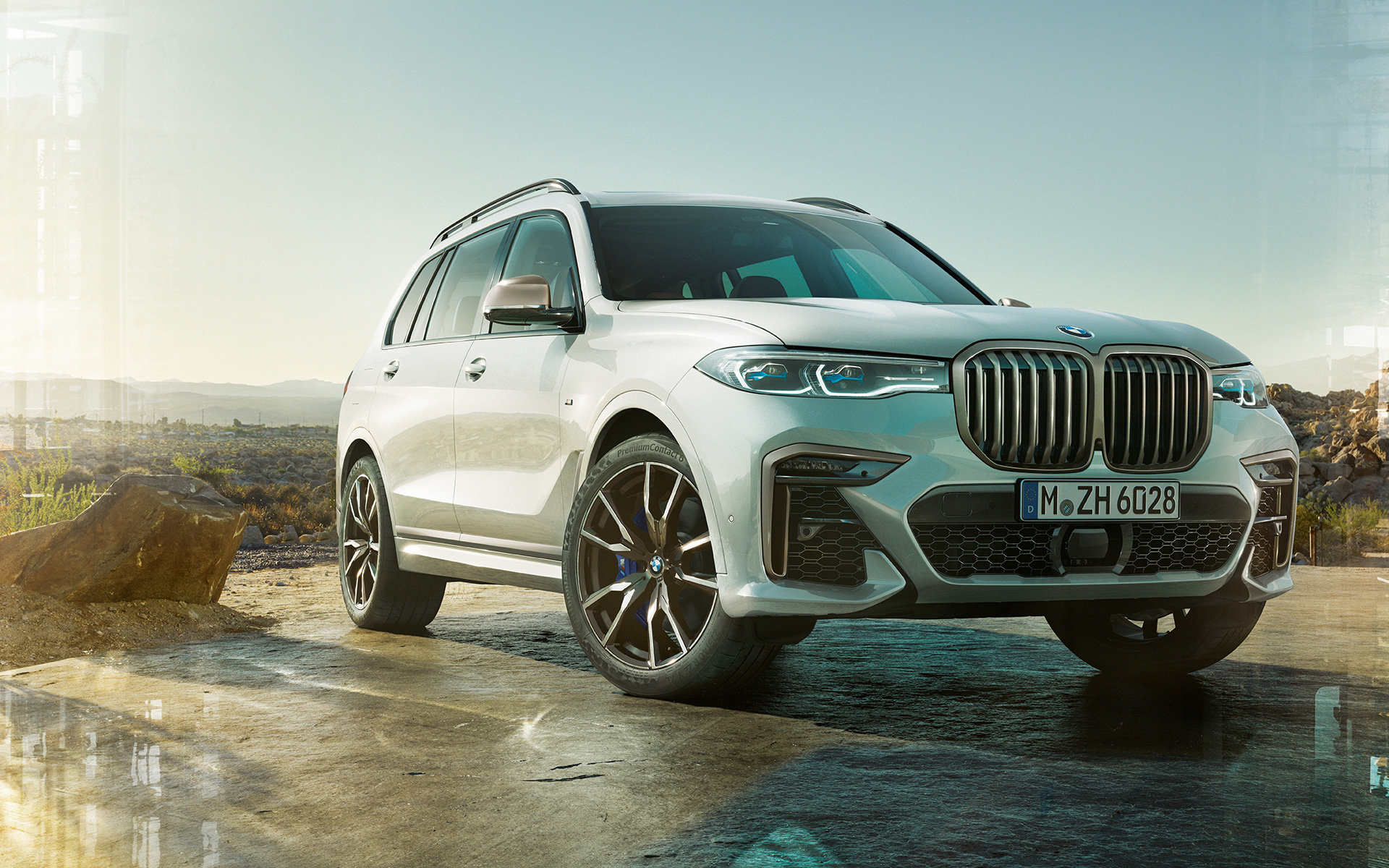 BMW X7 M50i G07 2019 Mineral White stående foran naturlandskab BMW X7 M50i G07 2019 Mineral White set forfra let drejet stående foran naturlandskab