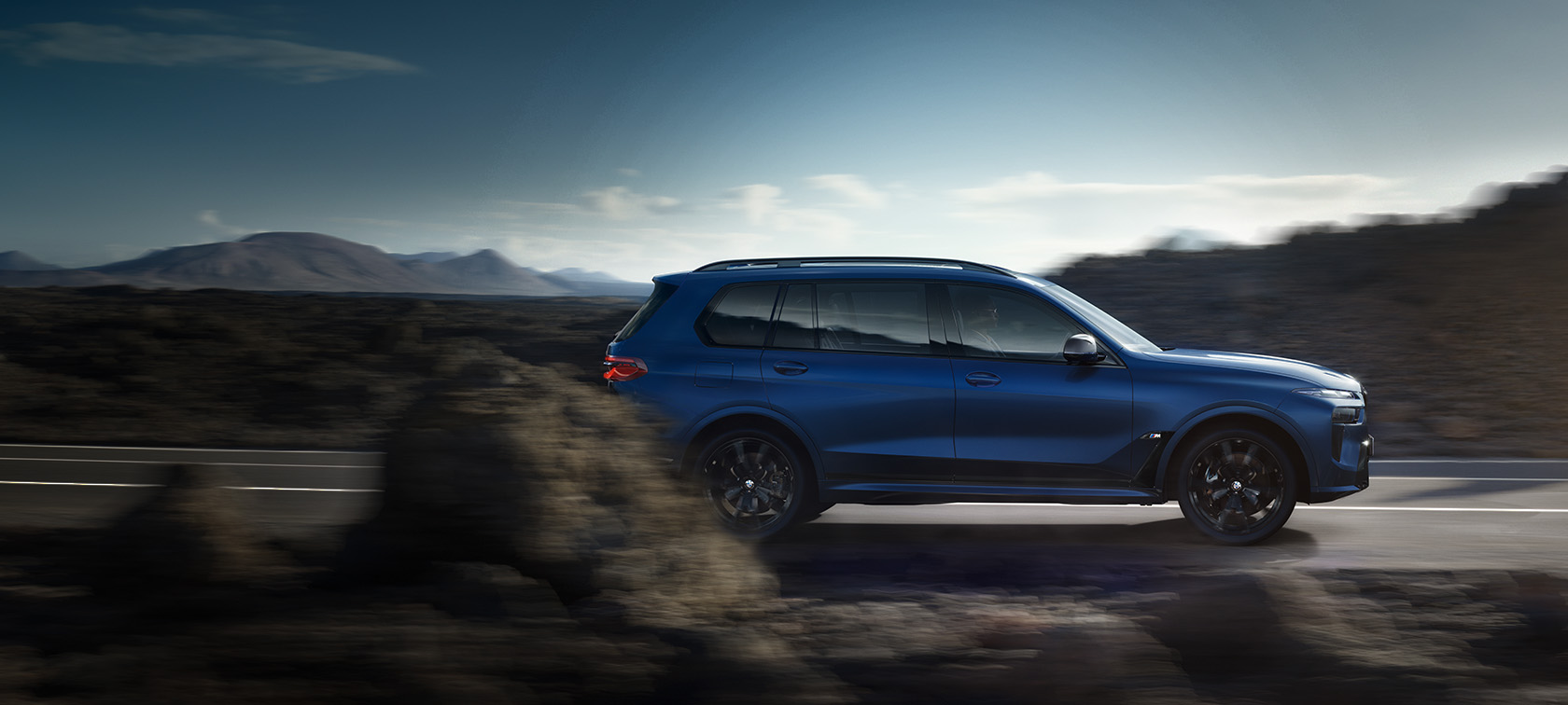 BMW X7 M60i xDrive G07 LCI Frozen Marina Bay Blue set fra siden kørende på en vej