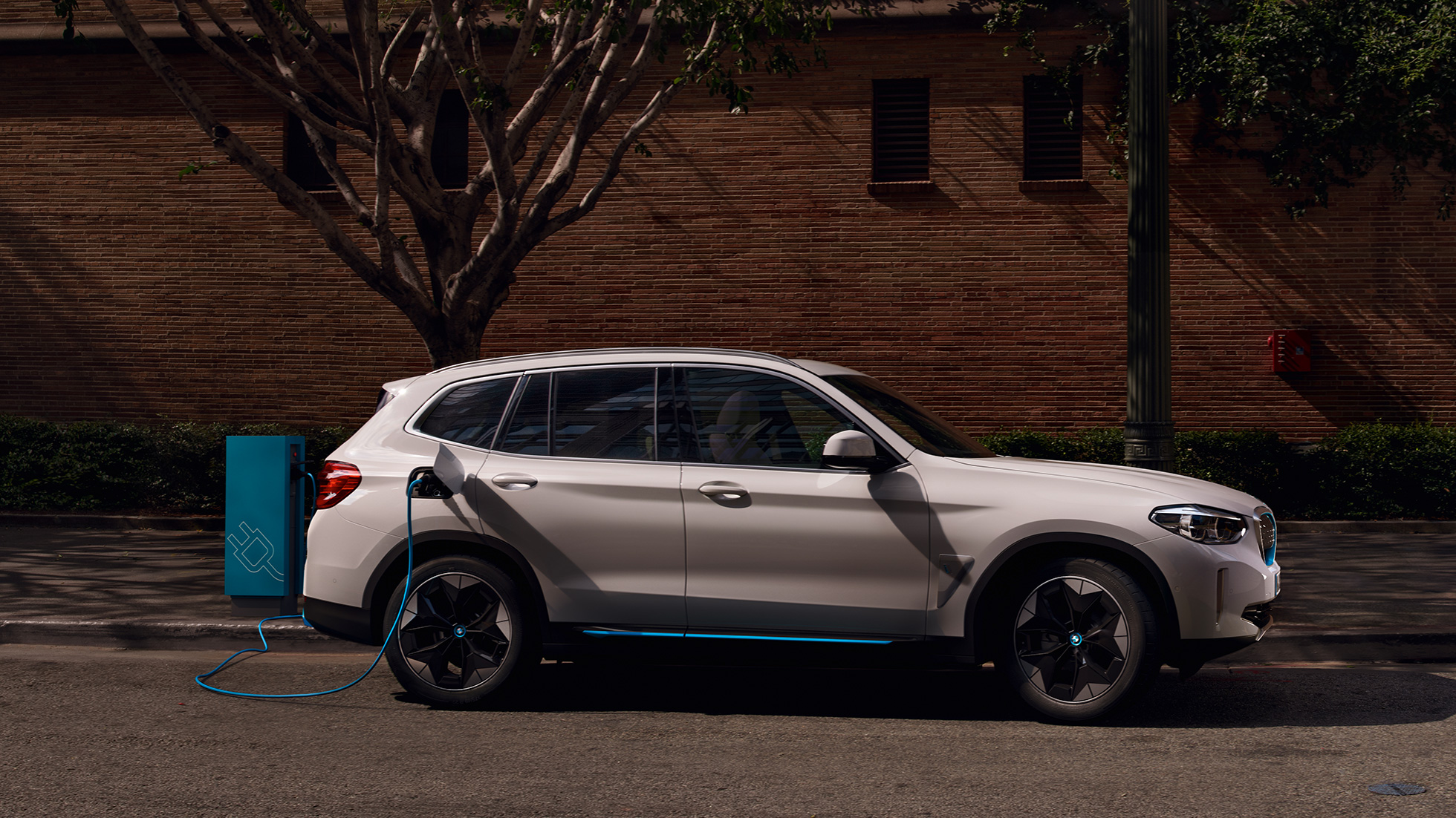 High-power charging BMW iX3 G08 set fra siden ved en offentlig ladestation High-power charging BMW iX3 G08 2020 Mineral White metallic set fra siden ved en offentlig ladestation.