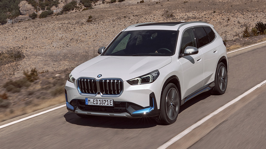 BMW iX1 U11 første generation set forfra let drejet kørende på vejen BMW X BMW iX U11 første generation set forfra let drejet kørende på vejen