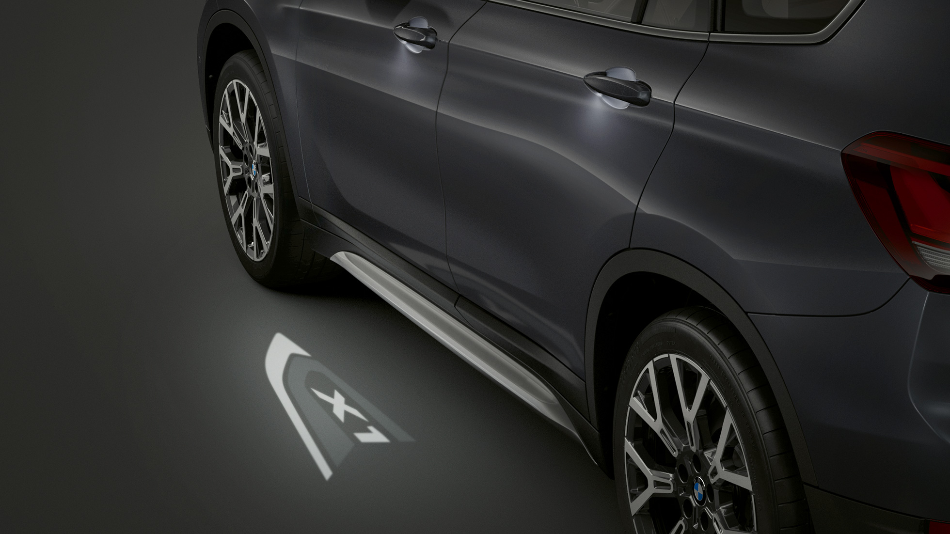 BMW X1, LED-projektion “X1”. BMW X1 set fra siden med fokus på LED-projektionen “X1”.