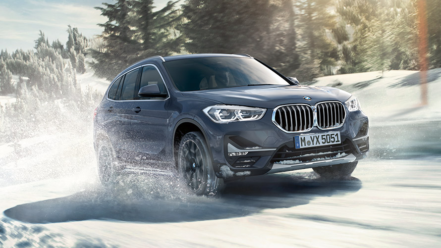 BMW X1 xDrive20i F48 LCI i BMW Individual Storm Bay metallic, kørende i vinterlandskab BMW X1 xDrive20i F48 LCI i BMW Individual Storm Bay metallic, kørende i vinterlandskab