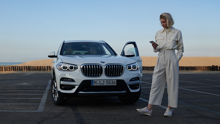 BMW X3 G01 katalog-app en kvinde ved siden af en BMW 2021 BMW X3 G01 katalog-app 2021