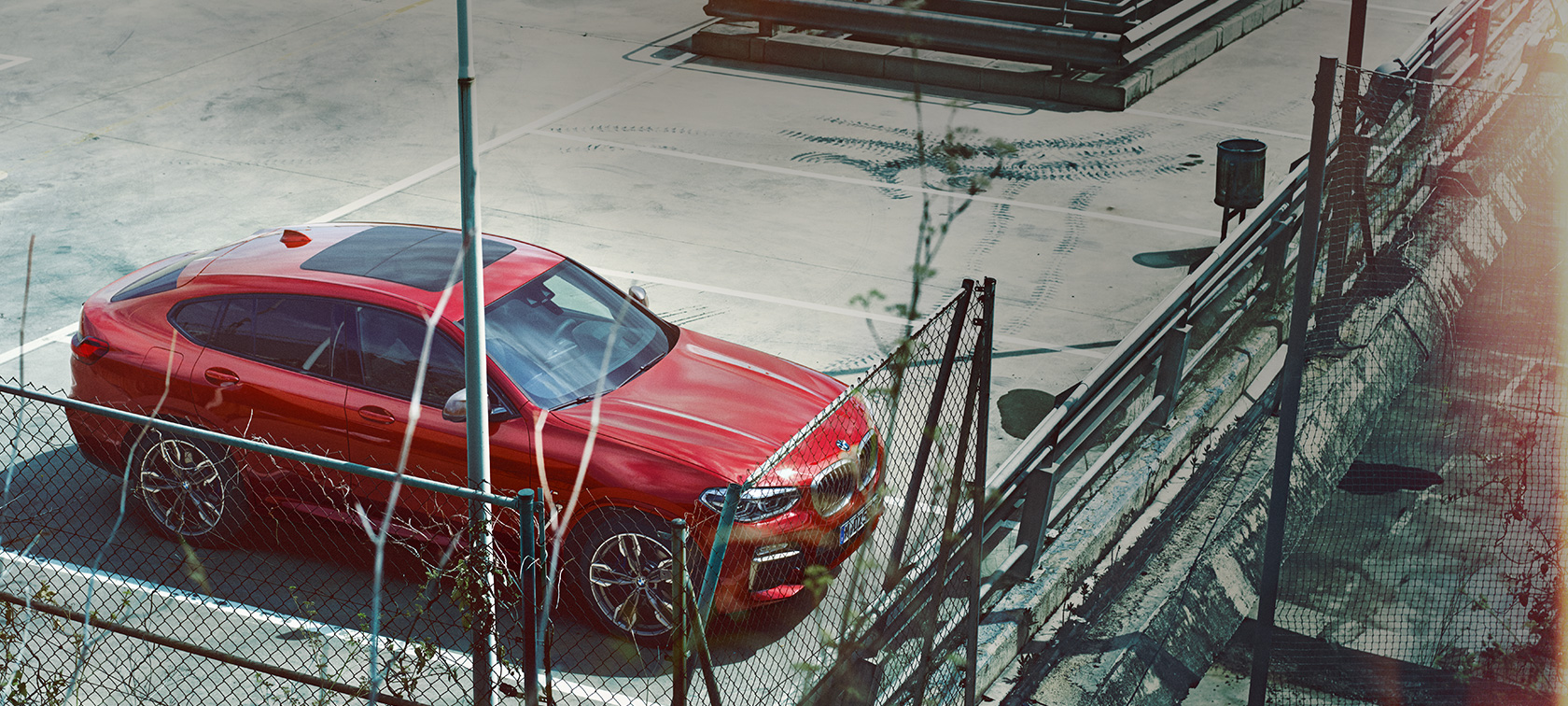BMW X4 parkeret BMW X4 G02 2018 Flamenco Red Brillant-effekt parkeret på parkeringsdæk set i fugleperspektiv