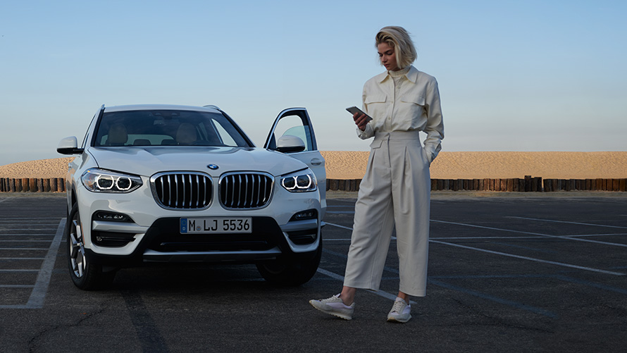 BMW X4 G02 Brochure App 2021 BMW X4 G02 katalog-app en kvinde ved siden af en BMW 2021
