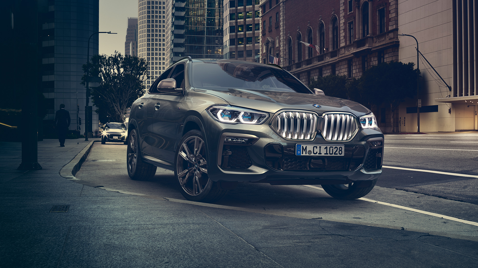 BMW X6 adaptiv M undervogn Professional. BMW X6 set forfra let drejet foran et urbant miljø.