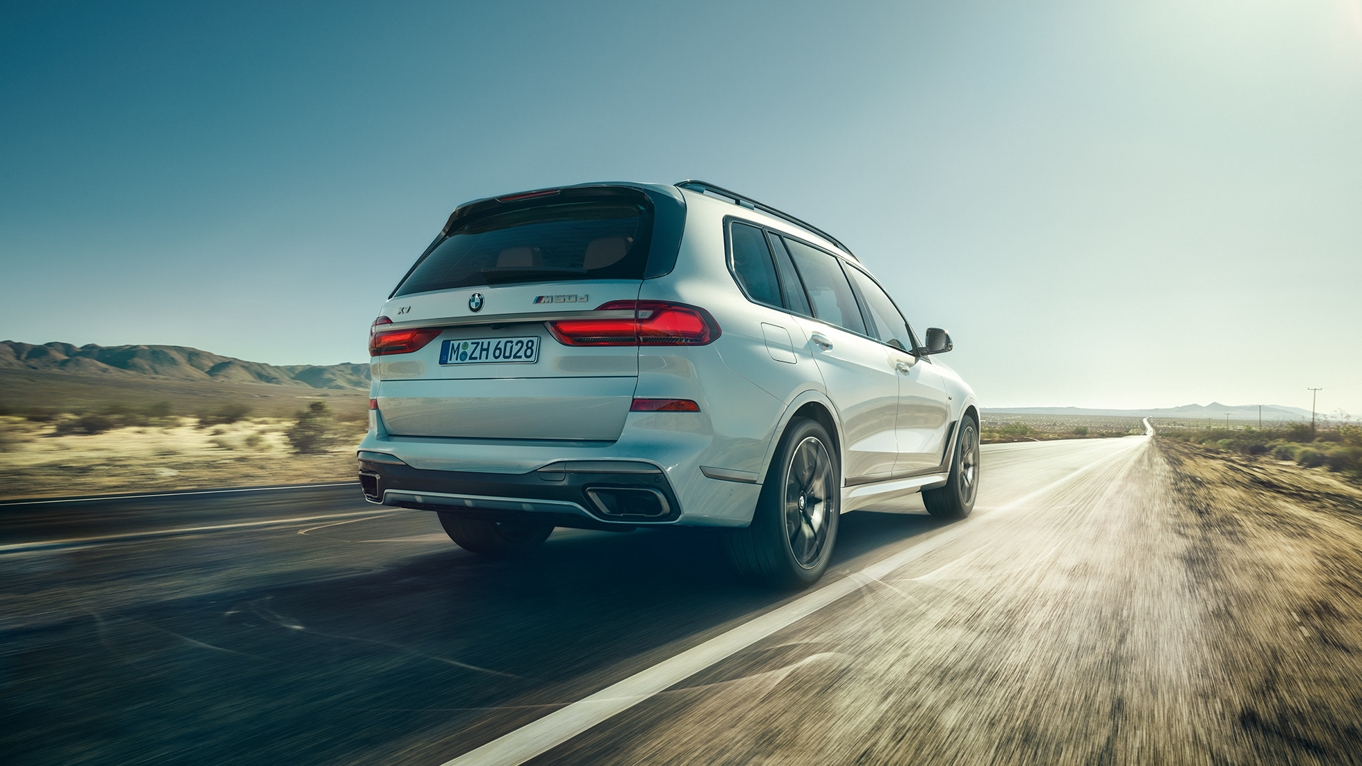 BMW X7 M50d, set bagfra BMW X7 M50d: Billede af kørende, hvid BMW X7 set bagfra