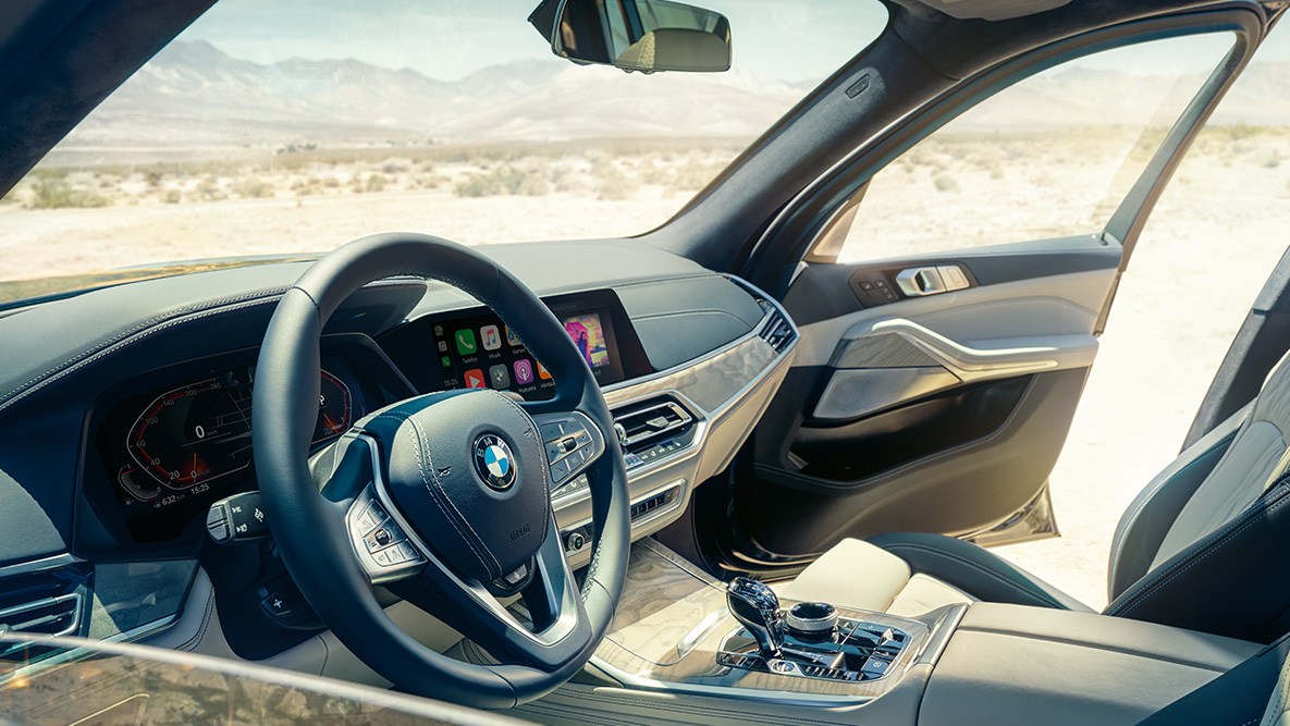 BMW X7 indvendigt BMW X7 indvendigt: et kig udefra og ind på første sæderække med fokus på rat, instrumentpanel og lædersæder