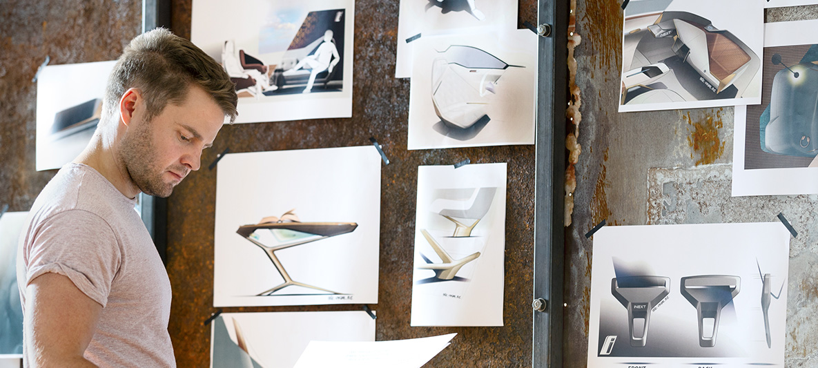Designskitser til BMW Vision iNEXT Mand foran væg med designskitser til BMW Vision iNEXT