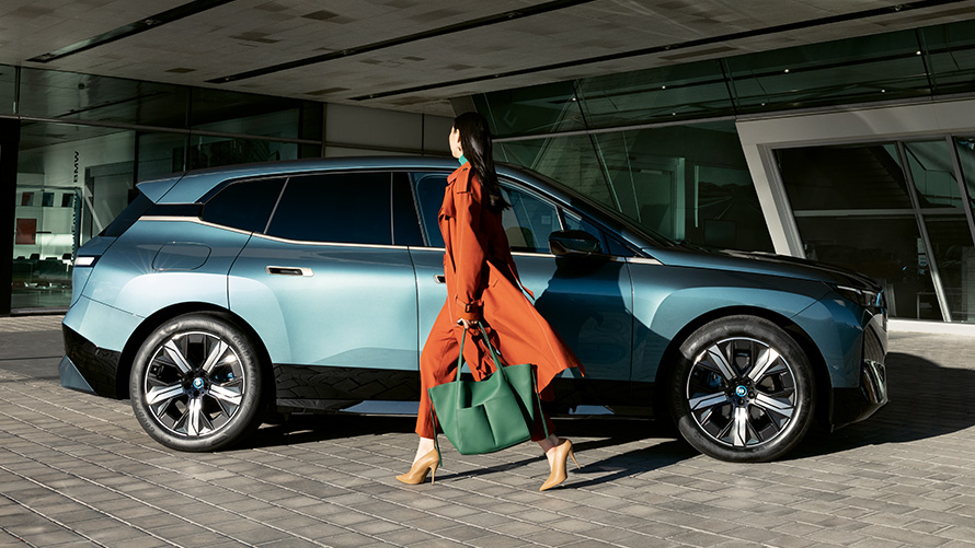 Anvendelse af BMW Digital Key BMW Digital Key anvendelse BMW iX i20 set fra siden med en kvinde i forgrunden