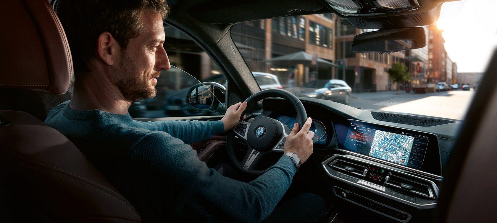 BMW Maps Navigation En mand kører i en BMW med BMW Maps Navigation i kontroldisplayet