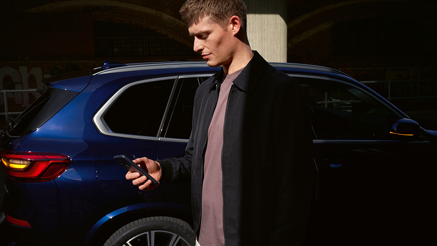 BMW Digital Key – opret op til fem brugere BMW Digital Key Opret op til fem brugere En mand med en smartphone foran BMW X5