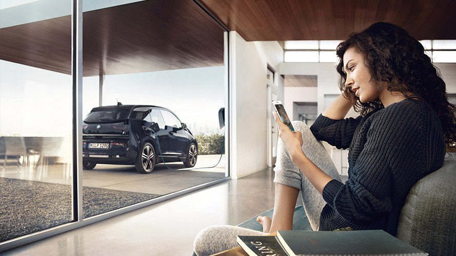 Digital Charging Service Kvinde bruger "Digital Charging Service" hjemmefra på smartphone for sin BMW i3
