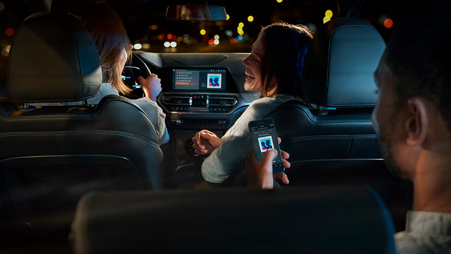 Connected Command Connected Command: Tre personer sidder i en BMW og hører musik, mens de kører