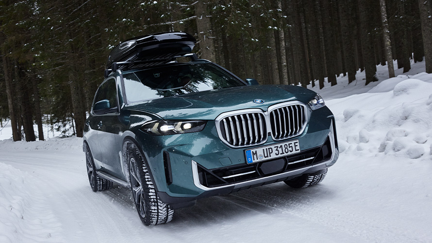 BMW godkendt komplet vinterhjul til BMW X5 (G05 LCI) på sneklædt vej i en skov BMW godkendt komplet vinterhjul til BMW X5 (G05 LCI) på sneklædt vej i en skov