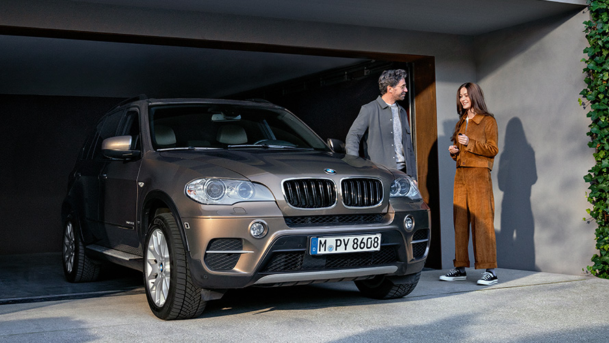 En BMW parkeret foran garage med modeller BMW Service 5+ En BMW parkeret foran garage med modeller