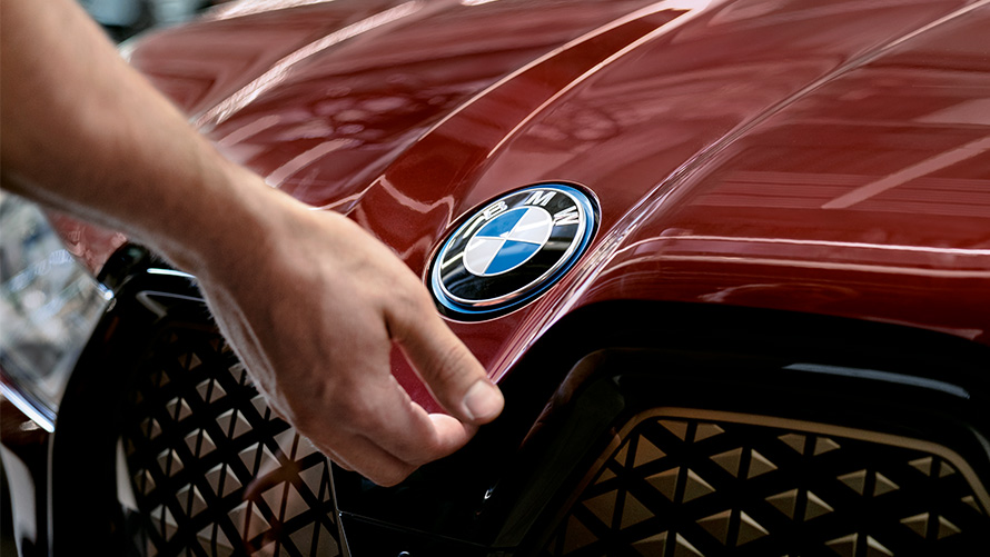 En BMW i sommerlige omgivelser med model BMW Service Inclusive En BMW i sommerlige omgivelser med model