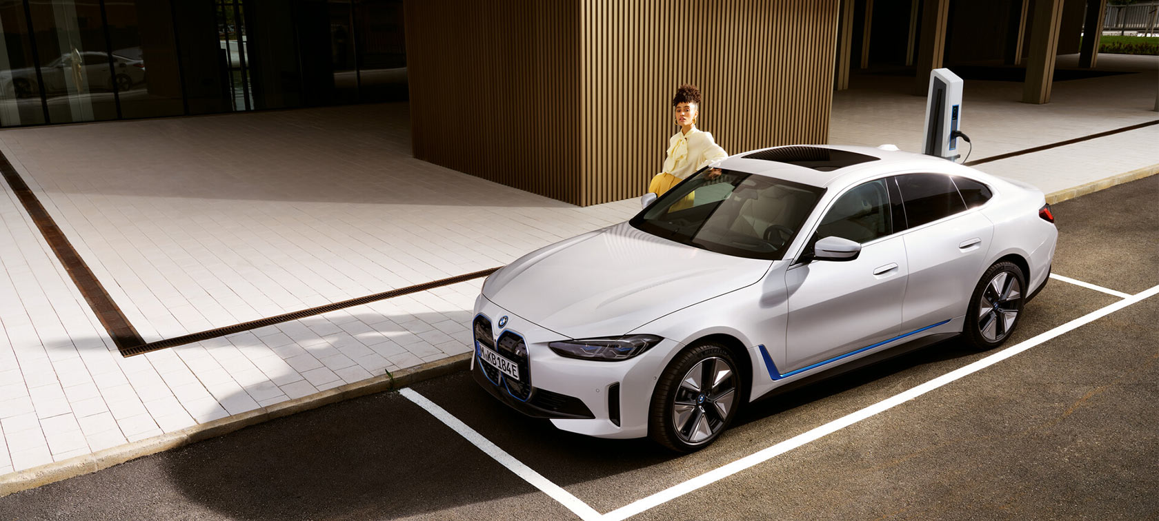 BMW i4 eDrive40 G26 2021 mineralhvid set forfra let drejet parkeret ved havet med bakker i baggrunden