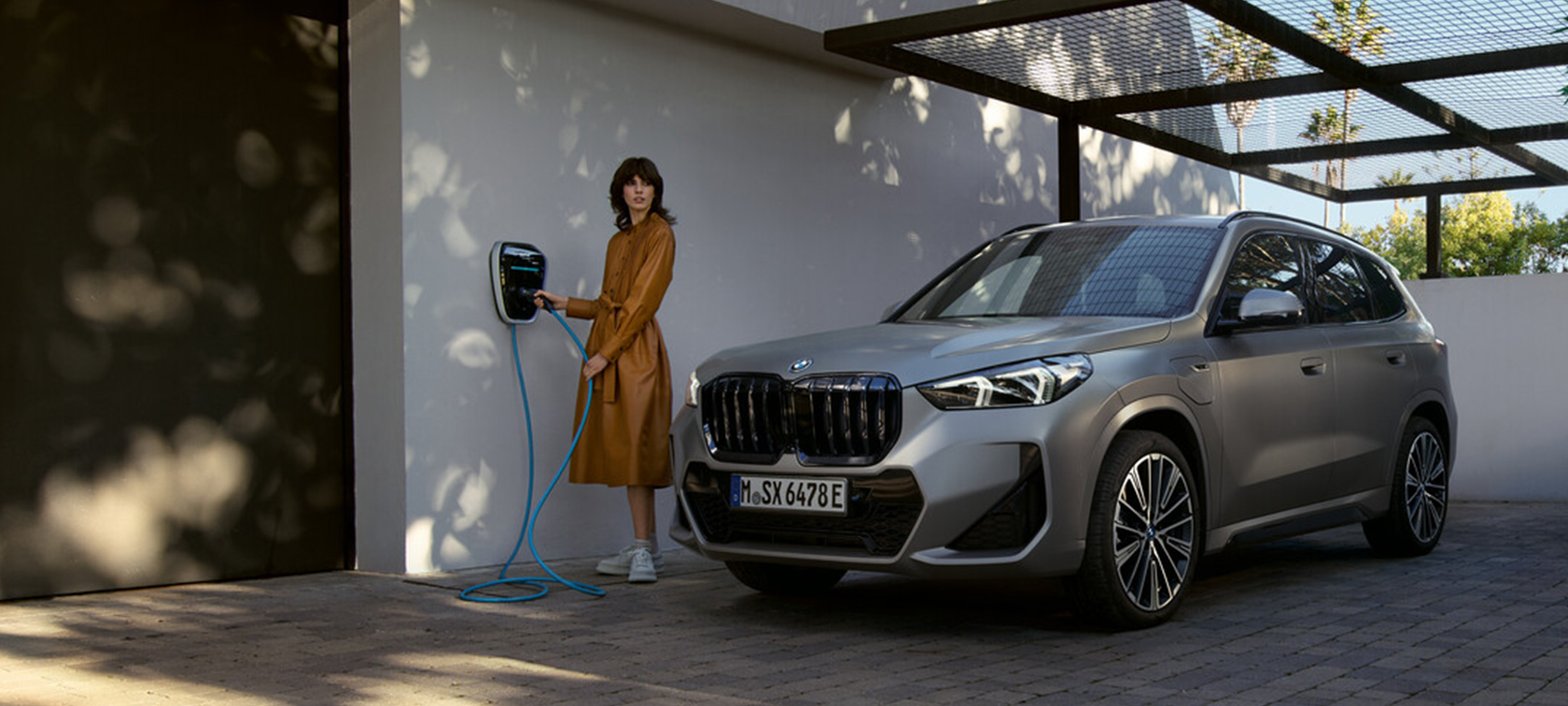 BMW X1 U11 xLine Utah Orange metallic set forfra let drejet kørende på en landevej