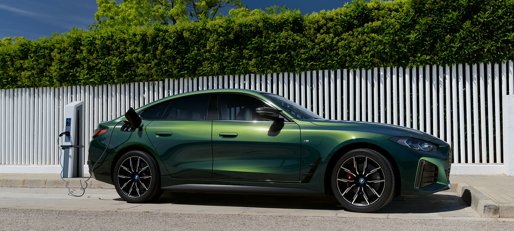 BMW i4 eDrive40 G26 2021 mineralhvid set forfra let drejet parkeret ved havet med bakker i baggrunden