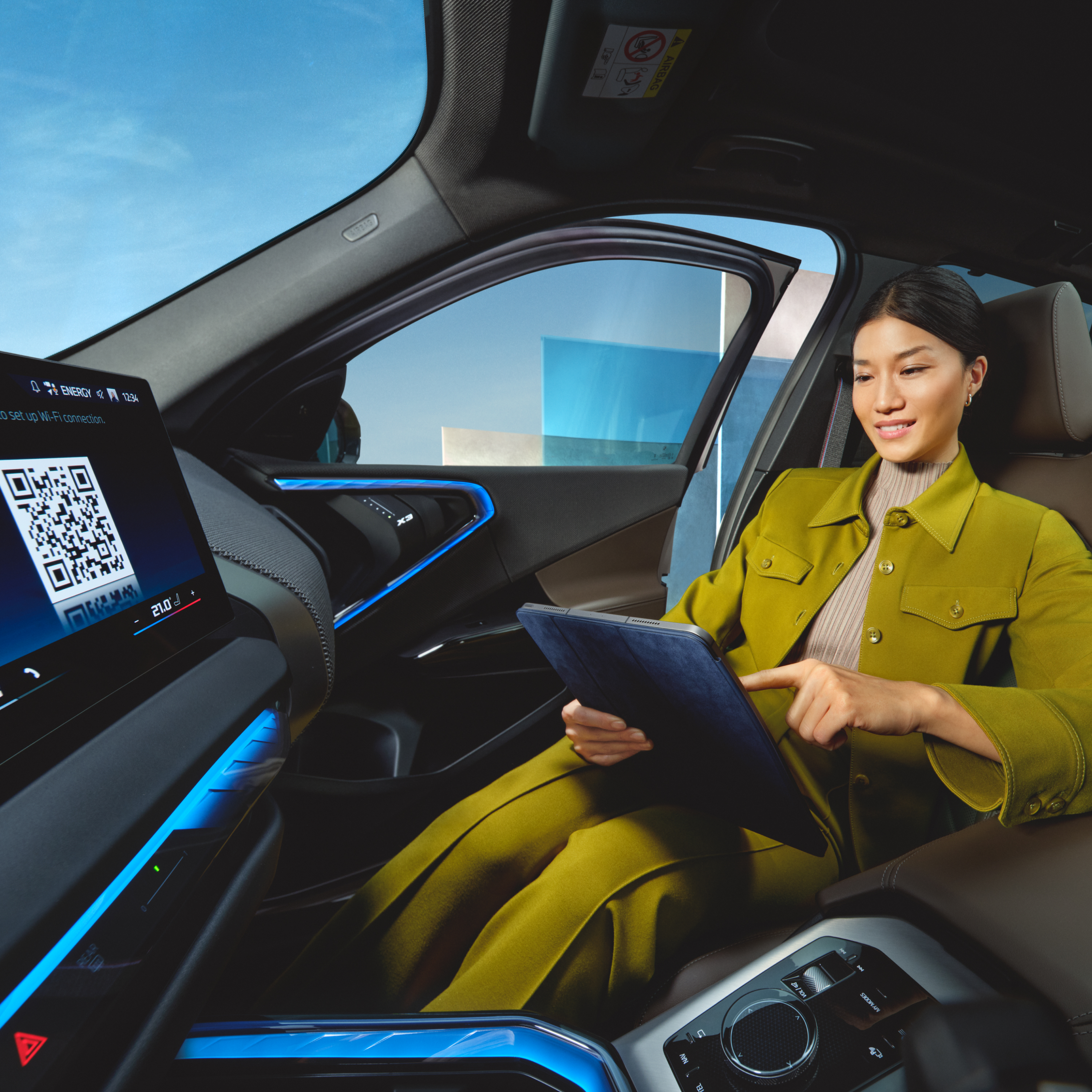Personen bruger tablet i en BMW