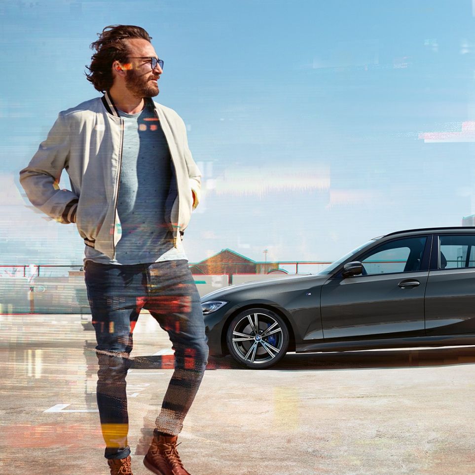 BMW 3-serie Touring, billede fra siden, design BMW 3-serie Touring, billede taget fra siden på et parkeringsdæk foran bymæssige omgivelser